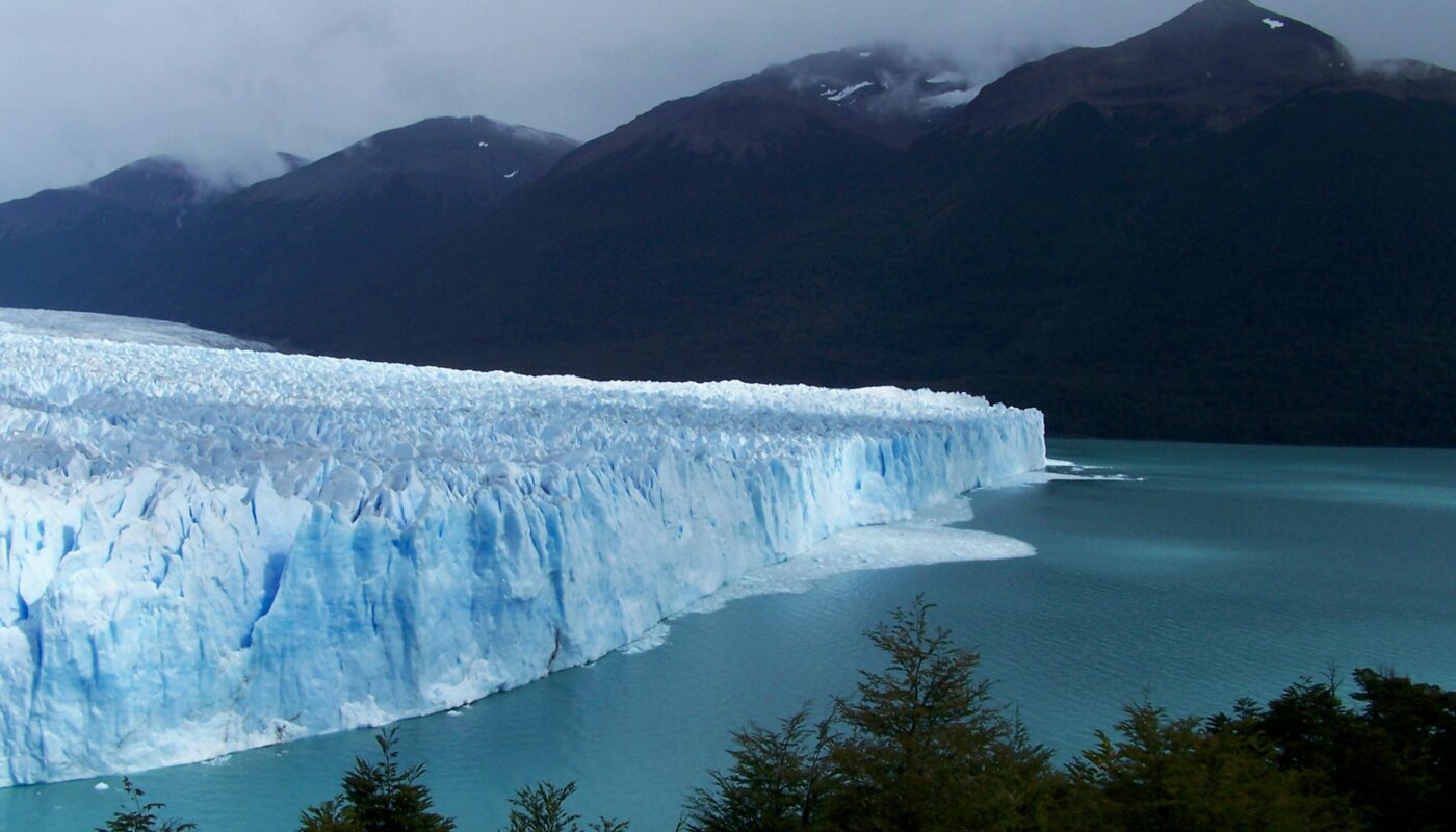 https://www.pexels.com/photo/glacier-between-body-of-water-and-mountains-5957676/