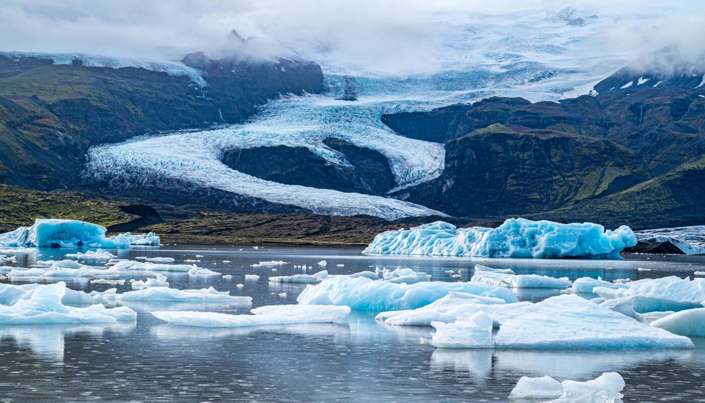 https://www.pexels.com/photo/ice-on-sea-shore-with-glacier-behind-19320697/